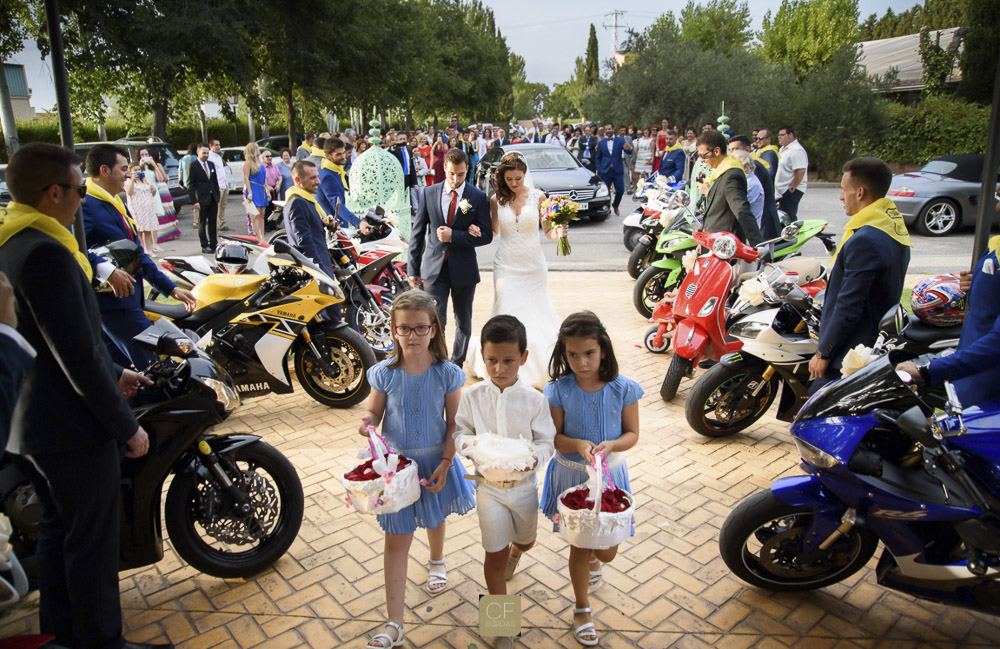 Me encantan las bodas con personalidad. Tres niños encabezan la entrada de la novia a la iglesia. CF Bodas. El álbum de bodas profesional.